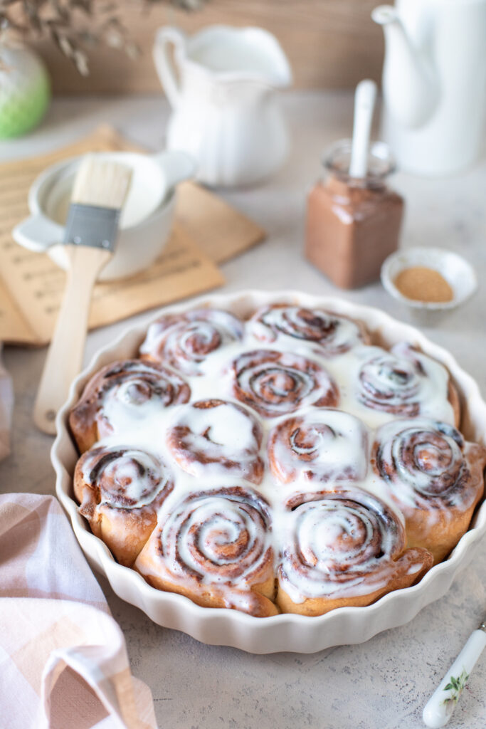 Golden brown sourdough cinnamon rolls with a glossy cream cheese glaze, fresh out of the oven.