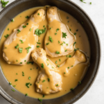 Raw chicken, butter, flour, chicken broth, and fresh herbs arranged on a kitchen counter, ready to make homemade chicken and gravy.